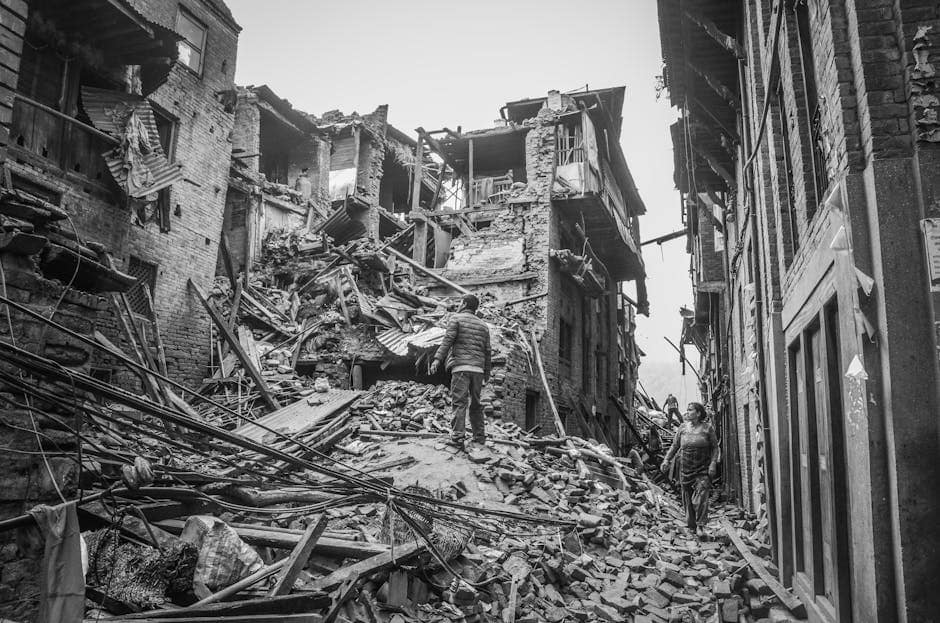 A monochrome view of earthquake aftermath in Bhaktapur, depicting urban destruction and damaged buildings.