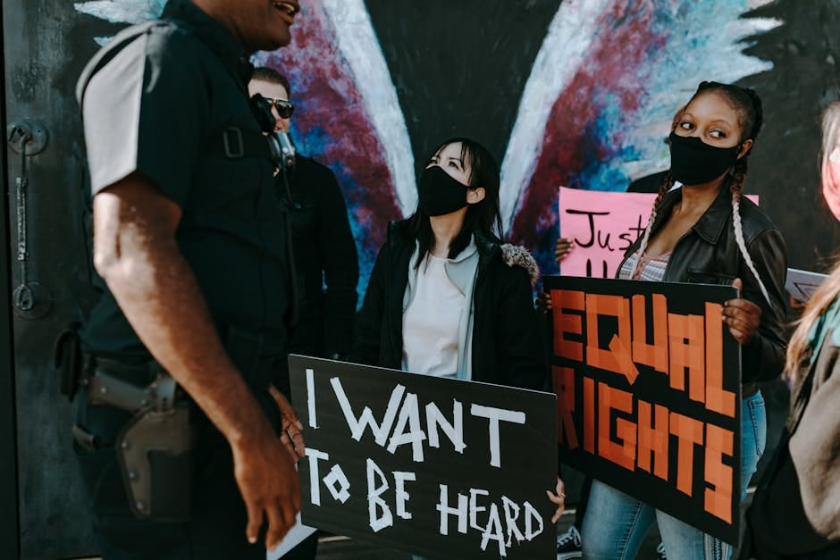 A diverse group protests for equal rights holding banners, seeking justice and unity.