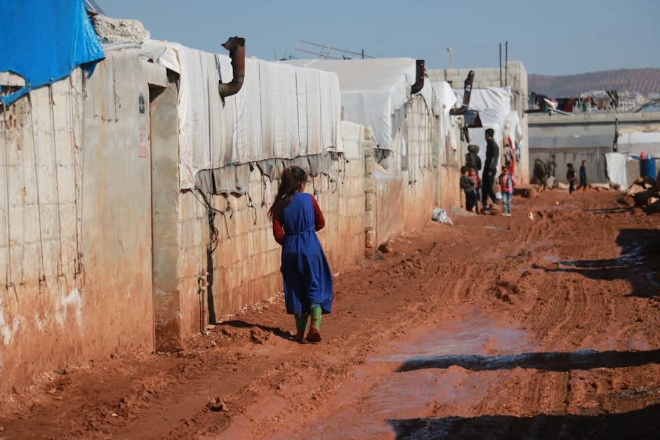 Young girl walks in a refugee camp in Idlib, Syria, highlighting displacement and resilience.