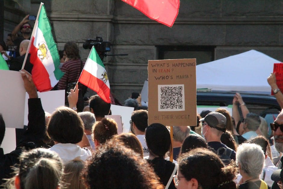 Crowd demonstrating in Vancouver with Iranian flags advocating for human rights and freedom.