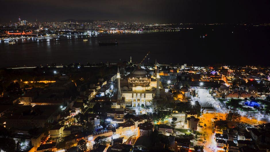 A breathtaking aerial shot of Istanbul's iconic Hagia Sophia at night, showcasing vibrant city lights.