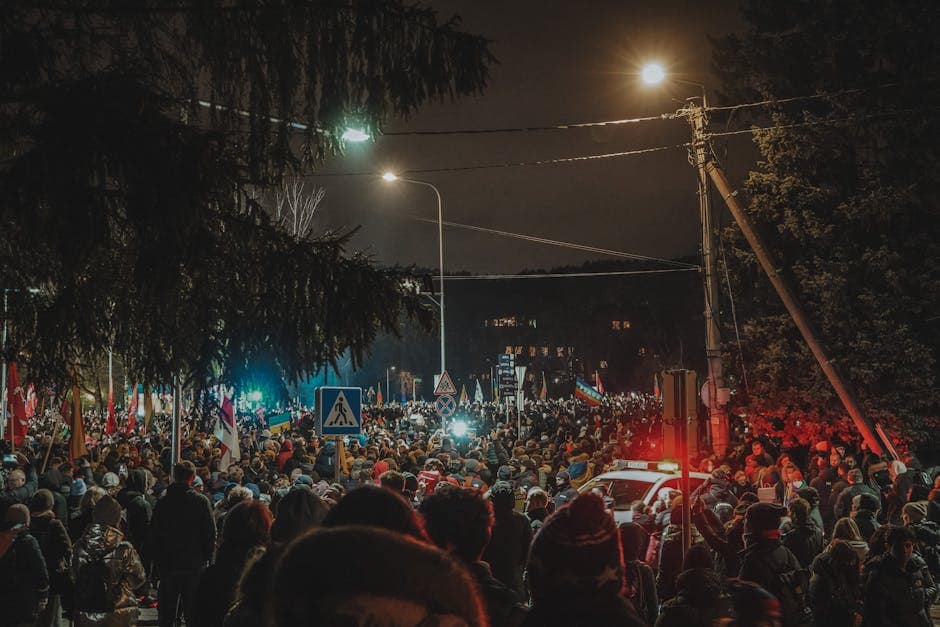 Crowd gathers peacefully at night protest in Lithuania streets.
