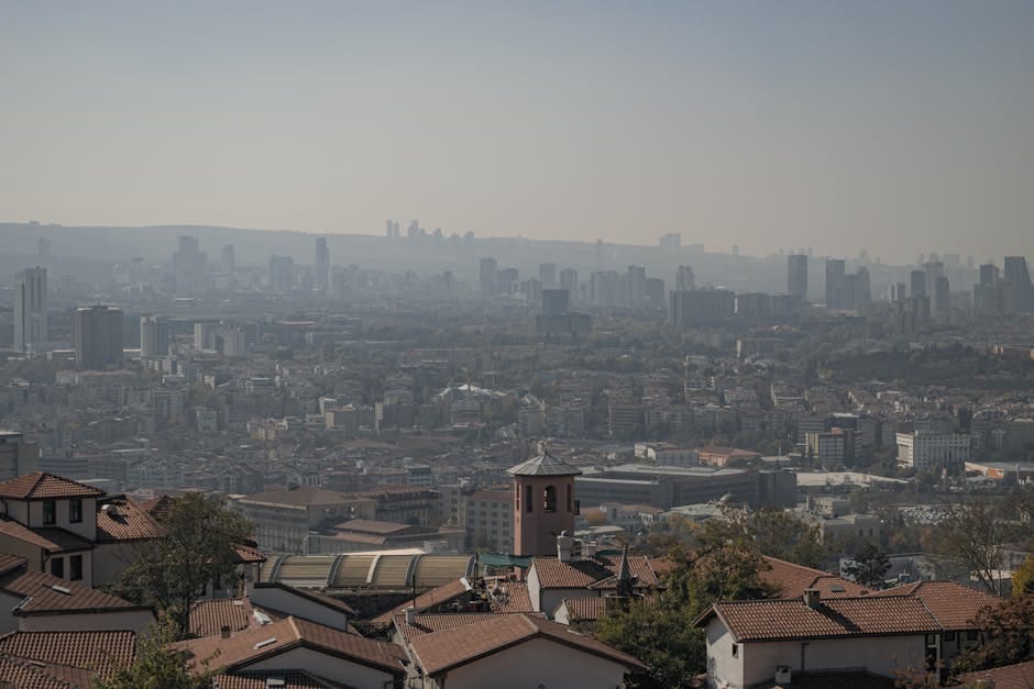 An aerial shot of Ankara's urban landscape, showcasing buildings under a hazy autumn sky.