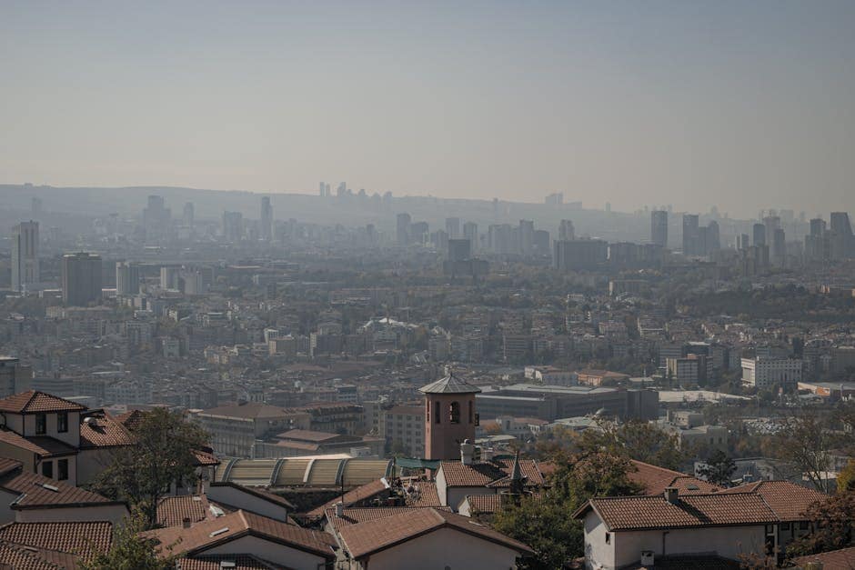 An aerial shot of Ankara's urban landscape, showcasing buildings under a hazy autumn sky.