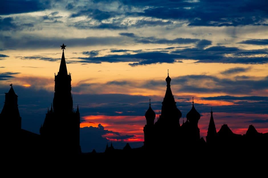 Dramatic silhouette of Moscow's iconic Kremlin towers against a vivid sunset sky.