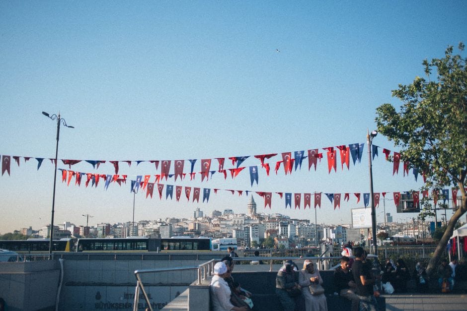 A bright day in the city with colorful Turkish buntings and a busy street scene.