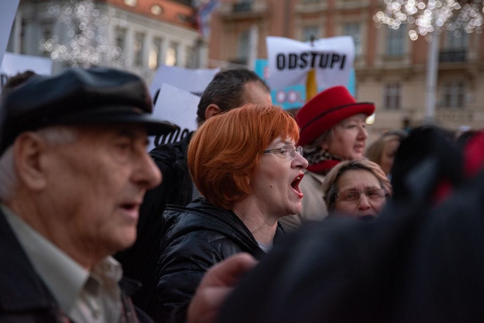 Crowd protesting in Zagreb, Croatia, showing diverse group voicing demands outdoors.
