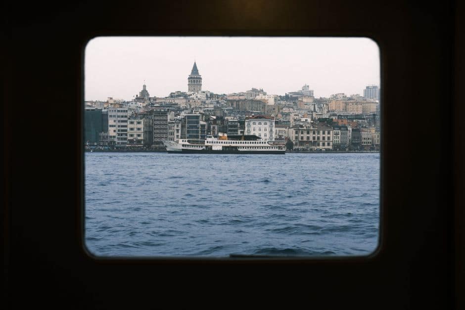 Stunning view of Istanbul skyline and Galata Tower through a ferry window.