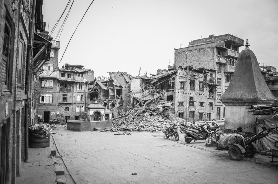 A monochrome view of earthquake aftermath in Bhaktapur, depicting urban destruction and damaged buildings.