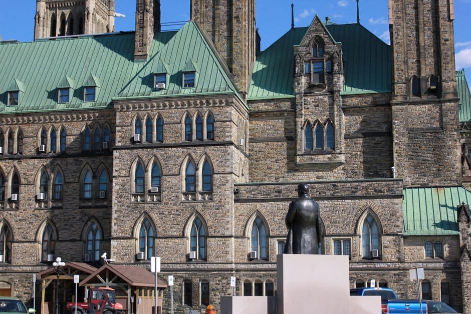 View of a historic Gothic Revival building with a statue in Ottawa, Canada.
