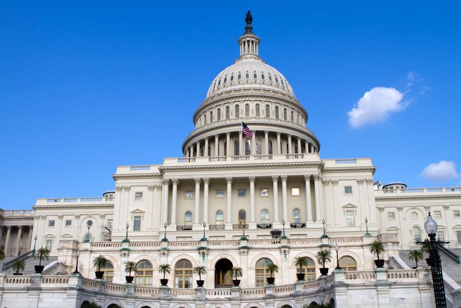 The United States Capitol Building in Washington, DC, with a clear blue sky.