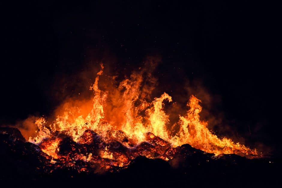 A fierce fire burning intensely at night in Torino, Italy, creating a dramatic scene.