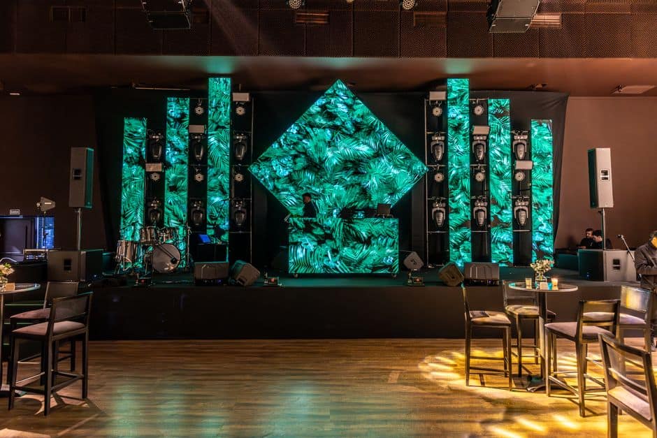 Stunning DJ booth setup with green LED panels in a modern indoor venue.